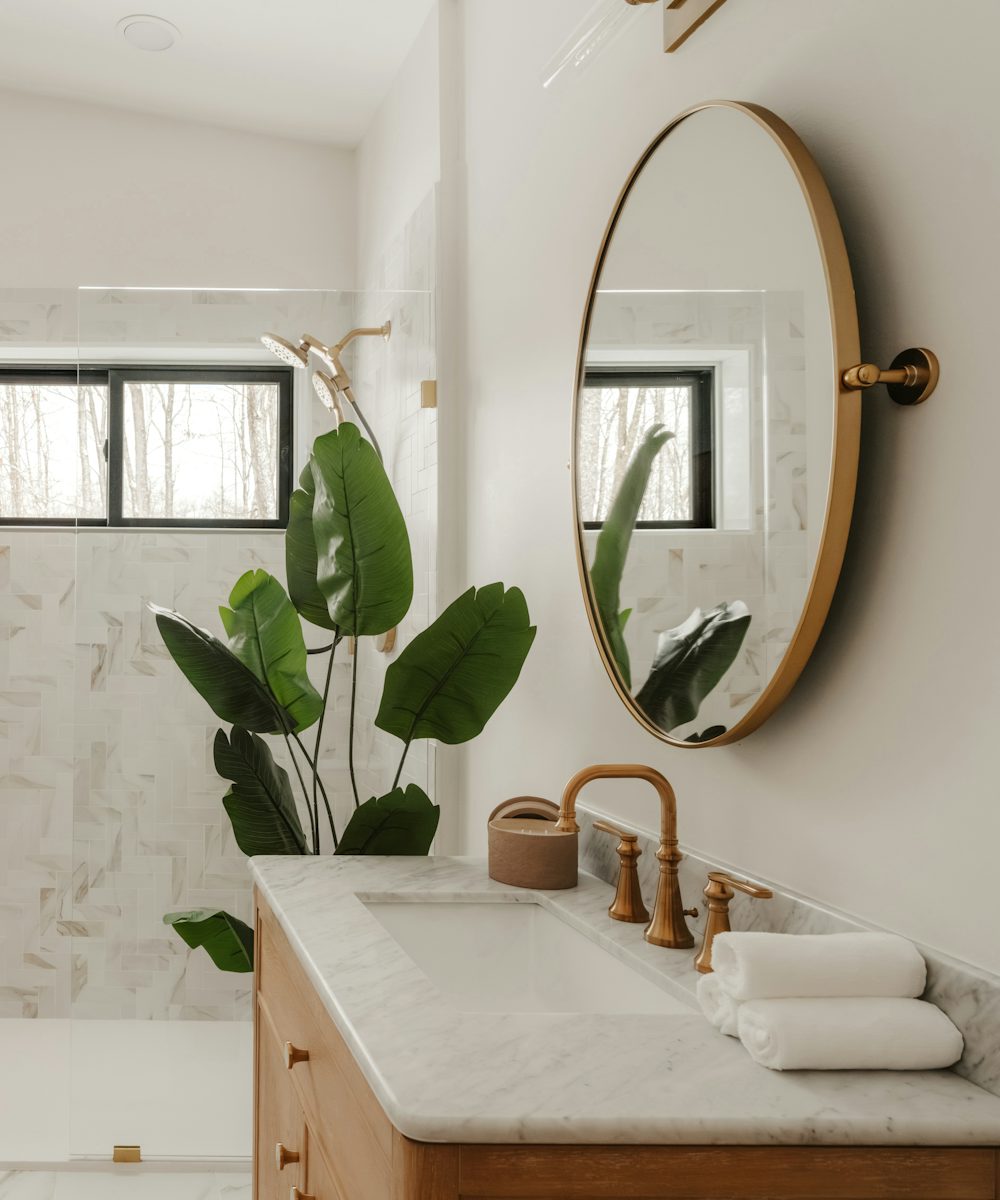 A finished modern bathroom with marble and a plant
