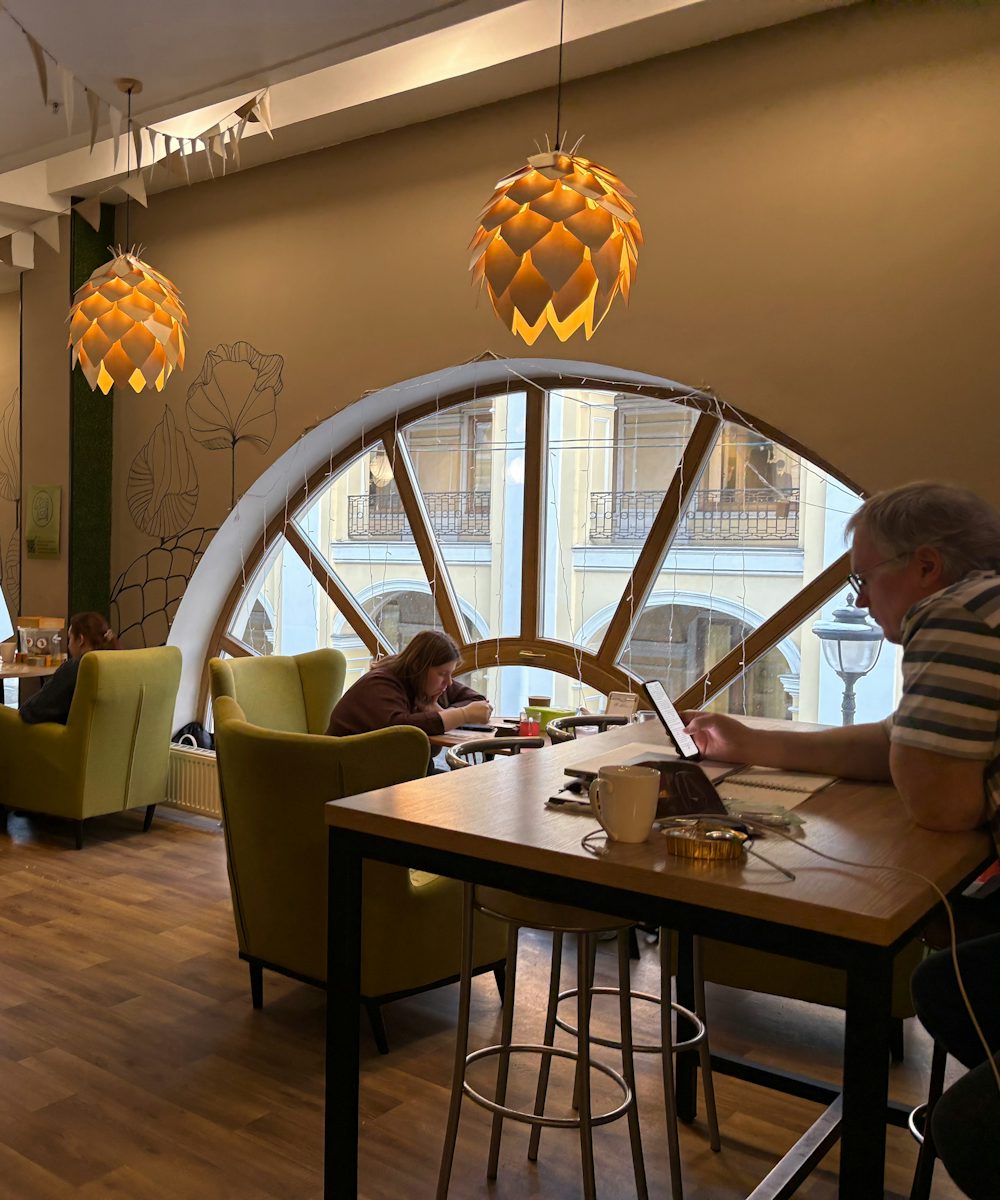 Customers relaxing by a large arched window