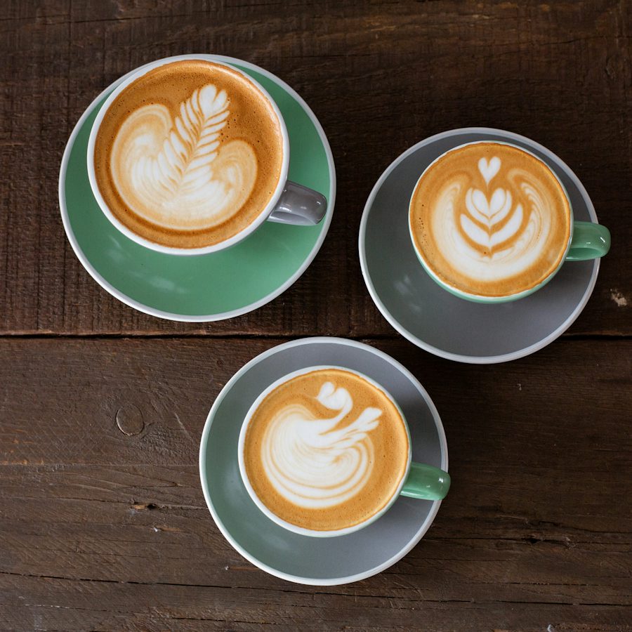 Three lattes on a wooden table