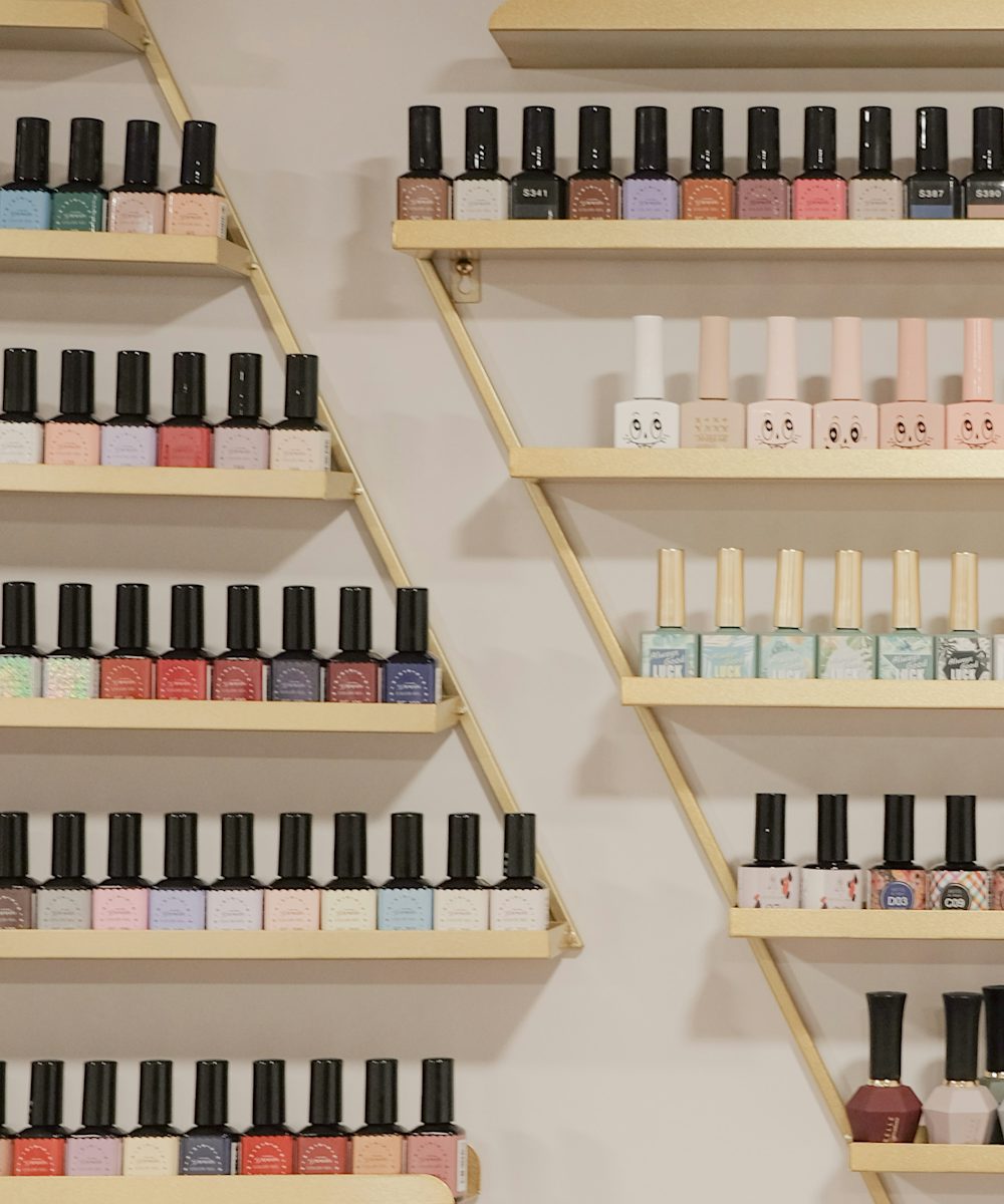 Rows of nail polish on gold shelves