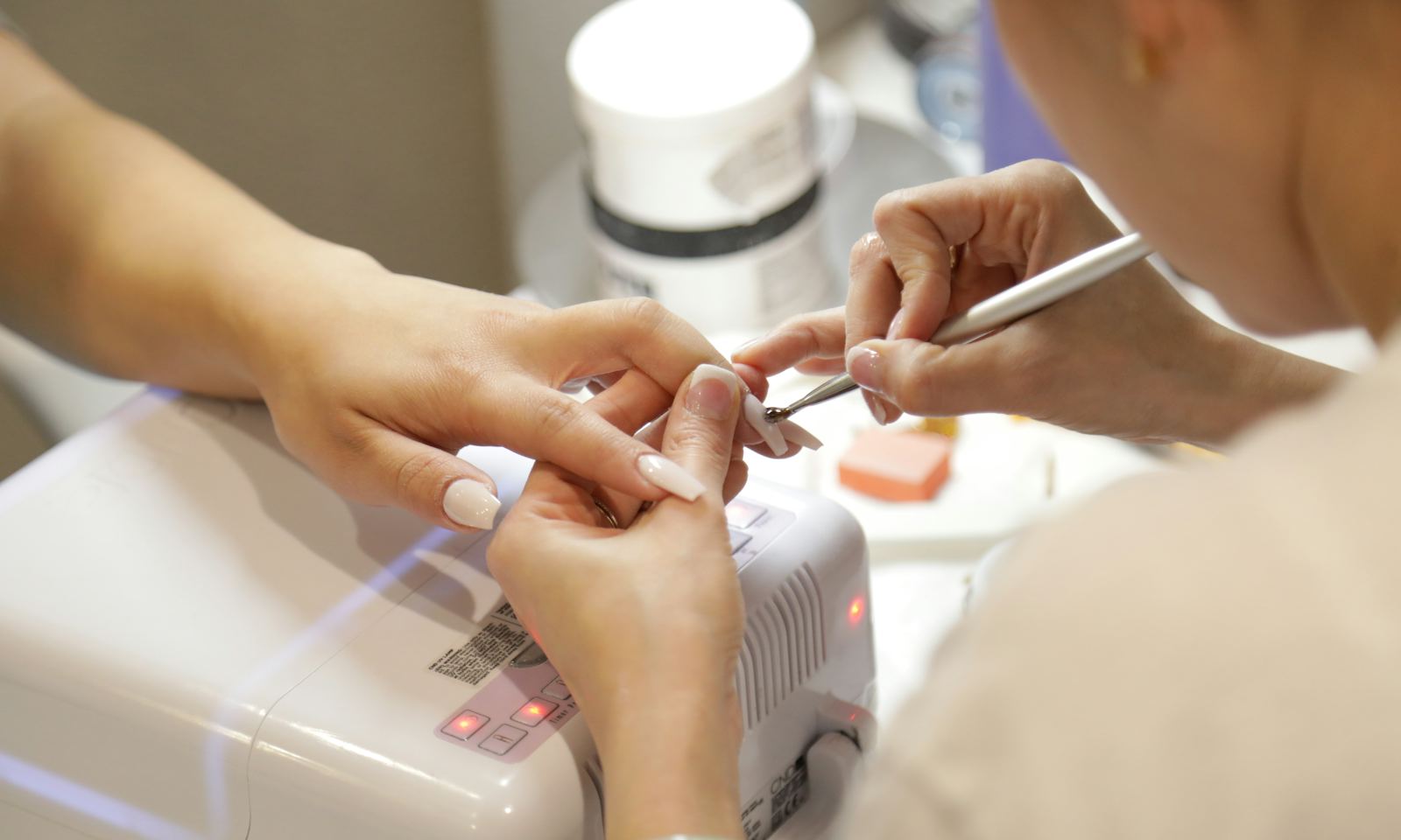 A nail technician carefully shaping a client’s nails