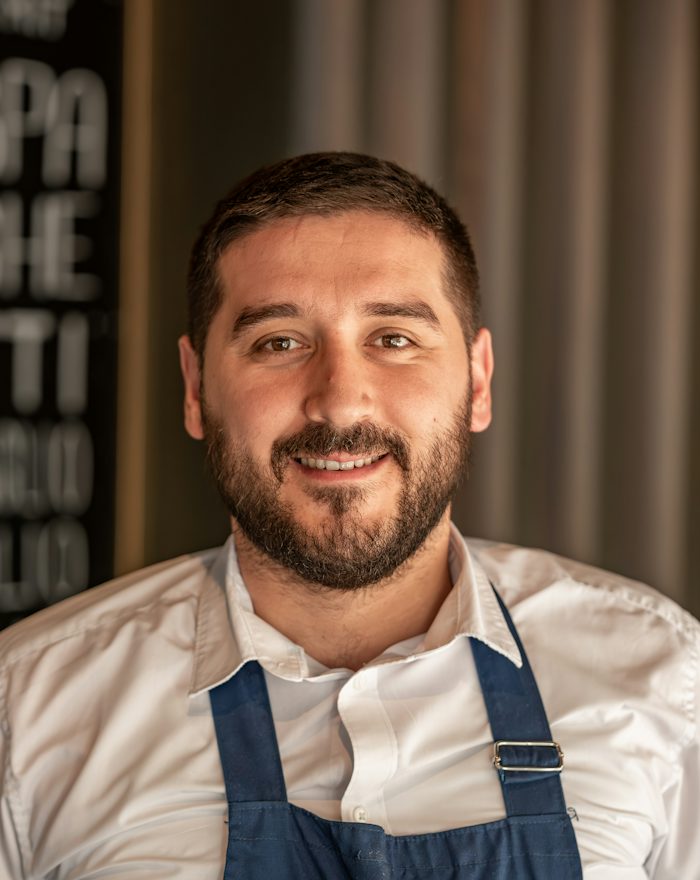 Ruairí, a bearded chef in a blue apron