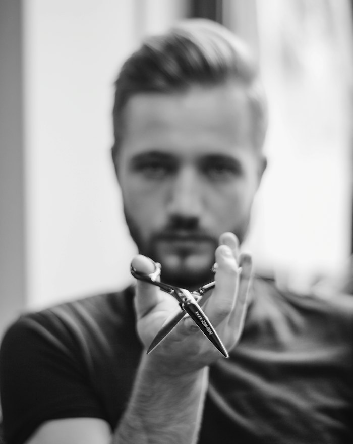 Cian holding a pair of barber scissors