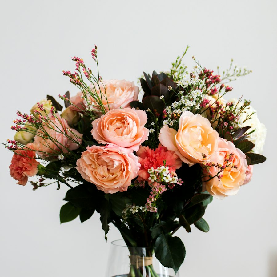 Pink, cream and red flowers in a glass vase
